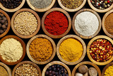Background of arranged spices in small wood bowls from above.