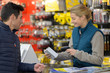 © auremar - female hardware store seller scanning clients item