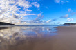 Beautiful scene cloudy blue sky reflected on beach wet sand
