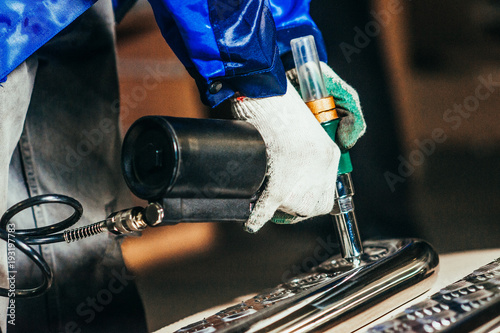 Fotografie, Obraz Man is working with a pneumatic rivet gun. Toned image.