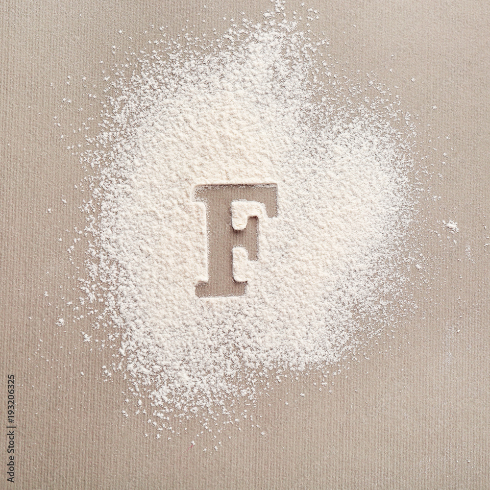 Silhouette of letter F on scattered flour