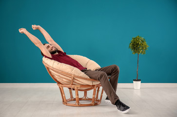 Wall Mural - Handsome man relaxing in comfortable armchair at home