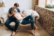 © Kateryna - Young beautiful couple spending time together sitting on a cozy sofa in a bright interior room