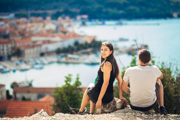 Cheerful young couple having a field trip date.Cityscape sightseeing,seaside travel vacation.Traveling in Europe,visiting Mediterranean road trip.Romantic vacation.Explorer active lifestyle.