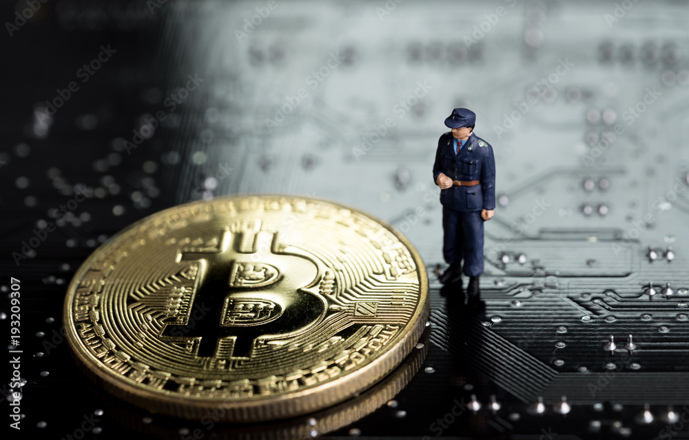 Block chain and Bitcoin safety or security trust concept, miniature figure security guard standing with gold bitcoin on computer technology look circuit board with soldering