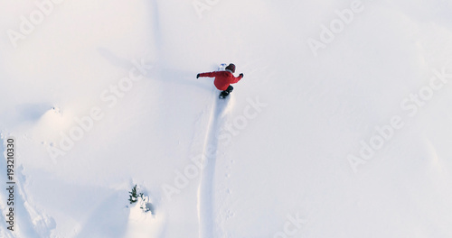 Fototapeta na szkło Snowboard widok z góry na dół na snowboardzistę jadącego przez świeży proszek Snow Down Ski Resort lub stok backcountry - tło sportów ekstremalnych