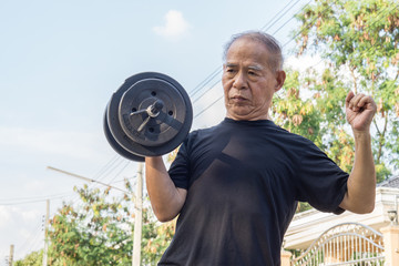 old asia man with dumbbells. person doing exercise outdoor. strengthen the muscles. your health is p