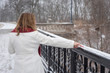 attractive woman walking in city park drawing line in fresh snow on railing