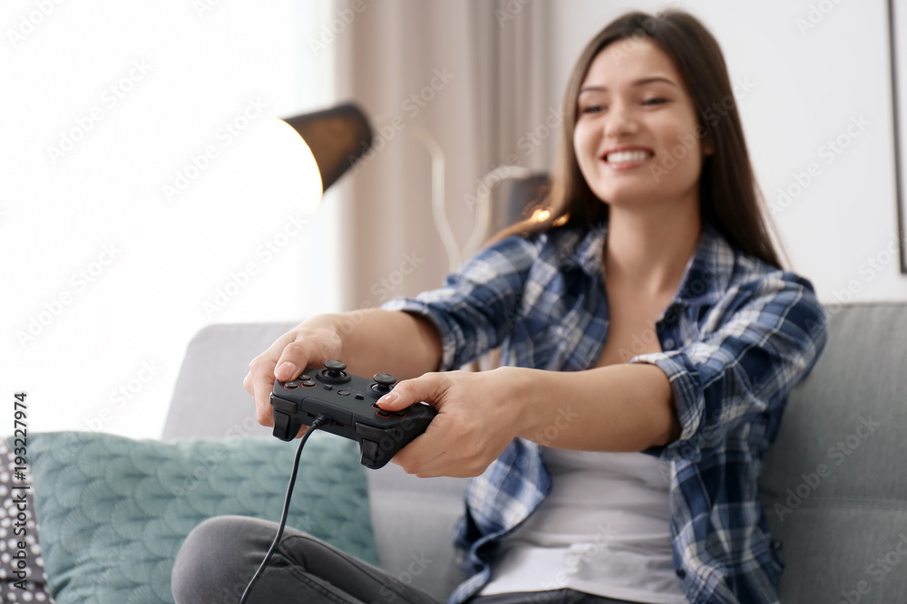 Young woman playing video games at home