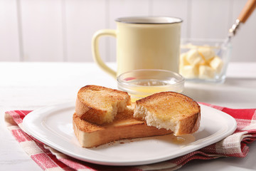 Sticker - Plate with tasty toasted bread and melted butter on table