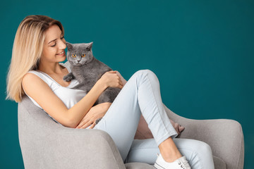 Wall Mural - Young woman with cute pet cat at home