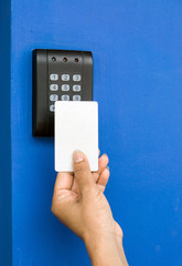 Door access control - young woman holding a key card to lock and unlock door., Keycard touch the security system to access the door