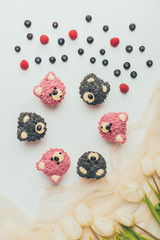 Wall Mural - top view of gourmet cupcakes in shape of bears, fresh berries and tulip flowers
