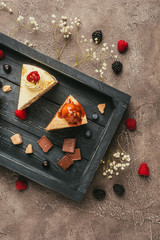 Wall Mural - top view of sweet tasty cakes with chocolate and berries on wooden tray