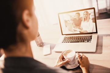 Poster - Composite image of businesspeople working over laptop at desk in