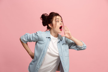Wall Mural - Isolated on pink young casual woman shouting at studio