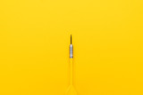 Fototapeta Dmuchawce - plastic dart with metal tip on the yellow background