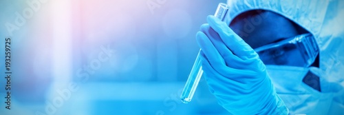 Cuadros en Lienzo Protected scientist looking at a dangerous liquid in test tubes
