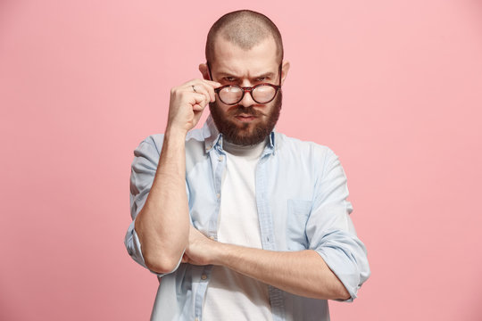 Suspiciont. Doubtful man with thoughtful expression making choice against pink background