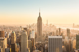 Fototapeta Fototapety do pokoju - New York City. Manhattan downtown skyline with illuminated Empire State Building and skyscrapers at amazing golden sunset. USA.