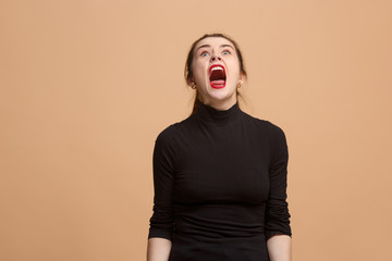Wall Mural - The young emotional angry woman screaming on pastel studio background