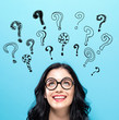 © Tierney - Question Marks with happy young woman on a blue background