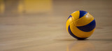 Volleyball ball on blurred wooden parquet background. Banner, space for text, close up view with details.