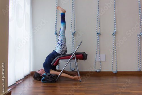 Yoga Teacher On Blue Outfit Stands Upside Down With Legs Straight