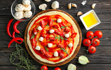 Sticker - Raw dough for pizza with ingredients on kitchen table