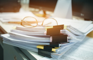 Canvas Print - Glasses placed on Unfinished documents stacks of paper files on computer desk for report , piles of unfinished papers achieves with clips, Business offices concept. Document is written,drawn,presented