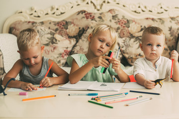 Wall Mural - Little Boys and Girl Drawing at Table at Home