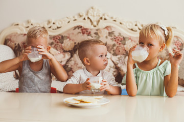 Wall Mural - Little Boys and Girl Drinking Milk at Table