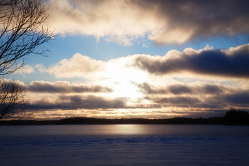 Wall Mural - View of the winter lake under the snow and sunset