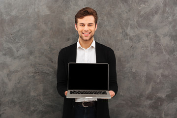 Sticker - Smiling businessman showing display of laptop computer.