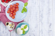 © Marina - Traditional Italian salad with fresh cherry tomatoes and soft mazarella cheese, with basil and olive oil. Ingredients for salad. Portions in plates. Free space for text.