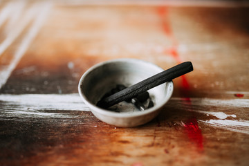 Artist's black charcoal on a wooden background.