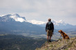 Man and dog on mountain top enjoying the view