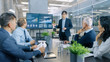 © Gorodenkoff - Asian Businessman Gives Report/ Presentation to His Business Colleagues, Pointing at the Results Showing Statistics, Pie Charts and Company's Growth On Wall TV Screen.