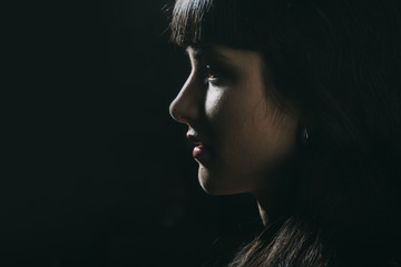 Girl with sensual face in dark room.