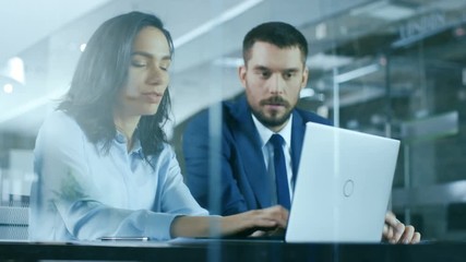 Wall Mural - Female Accountant and Male Businessman Sitting at the Desk Having Discussion and Working on a Desktop Computer, Solving Problems. Shot on RED EPIC-W 8K Helium Cinema Camera.