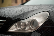 Modern Car Headlights With Rain Drops. Transportation Background.