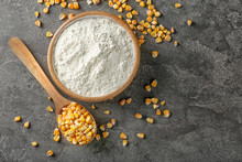 Spoon With Kernels And Corn Starch In Bowl On Table