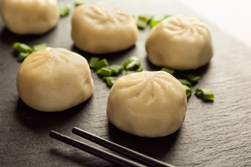 Wall Mural - Slate plate with tasty baozi dumplings, closeup