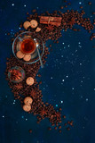 Fototapeta Kosmos - Coffee cup, chocolate chip cookies and scattered coffee beans. Creative top view hot drink concept with copy space. Ingredients for making coffee in a creative flat lay concept.