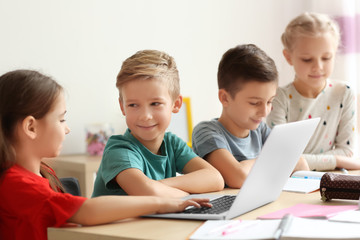 Cute children doing homework in classroom at school