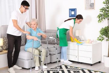 Wall Mural - Senior woman with young caregivers at home