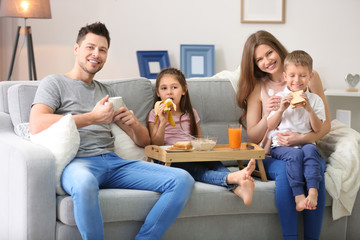 Wall Mural - Happy family having breakfast on sofa at home