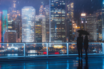 Wall Mural - People stand in Tsim Sha Tsui look at Hong Kong island at a rainy day