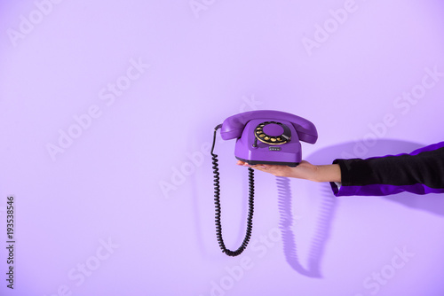 Fotografía cropped view of girl holding vintage rotary phone at ultra violet wall