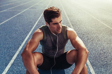 Wall Mural - sprinter relaxing on running track